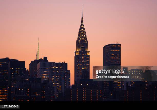 chrysler building verlicht bij zonsondergang, new york city skyline - chrysler building stockfoto's en -beelden