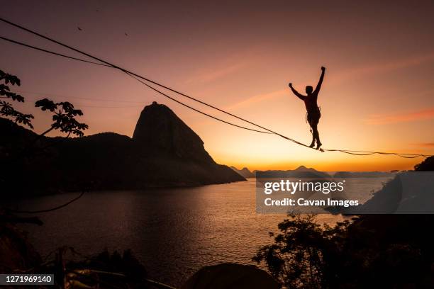 beautiful sunrise view of man walking on highline with sugar loaf - highlining stock pictures, royalty-free photos & images