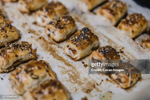 small buns with sesame on parchment - sausage roll stock-fotos und bilder