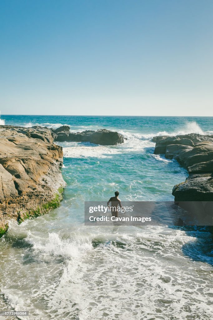 Young man swimming in Pacific Ocean swimming hole in Baja, Mexico.