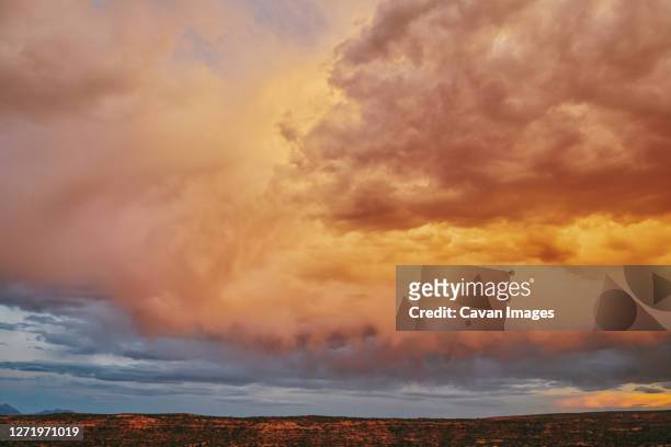 storm clouds during sunset over desert landscape in moab, utah. - golden hour stock pictures, royalty-free photos & images