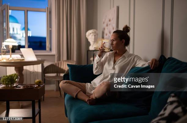 woman relaxing after work at home - dusk stock pictures, royalty-free photos & images