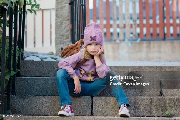 portrait of a young girl sat on a step with attitude waiting - aspettare foto e immagini stock