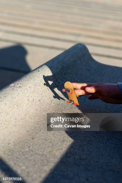 riding a mini skateboard or fingerboard on outdoors ramp - extreem weer stock pictures, royalty-free photos & images