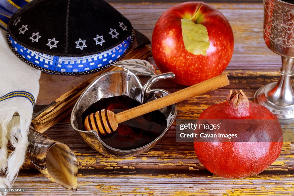 Shofar and tallit with glass honey jar and fresh ripe apples. Jewesh new year symbols. Rosh hashanah