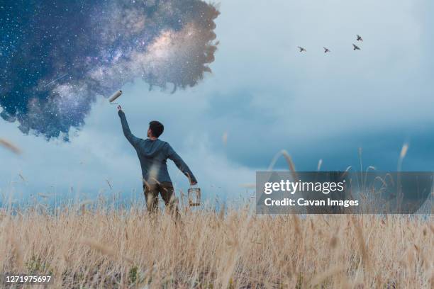 man painting stars in rural landscape - photoshop photos et images de collection
