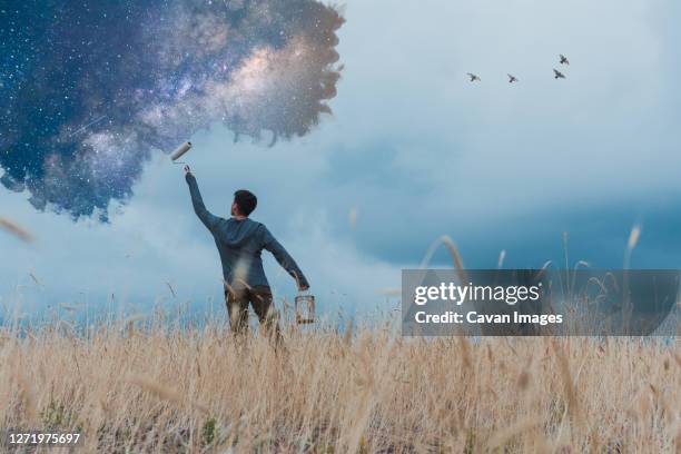 man painting stars in rural landscape - photoshop stock pictures, royalty-free photos & images