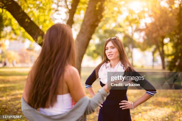 mujeres discutiendo en un parque público - friends argue fotografías e imágenes de stock