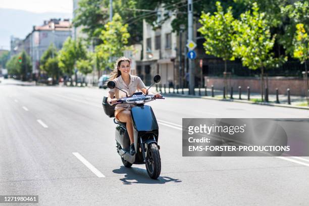 beautiful student is renting and riding an e-scooter in the city sofia - safe driving stock-fotos und bilder