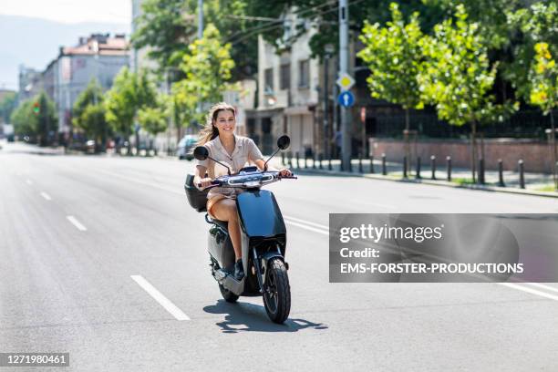 beautiful student is renting and riding an e-scooter in the city sofia - motor scooter stock pictures, royalty-free photos & images