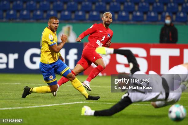 Matheus Cunha of Hertha Berlin scores his team's second goal past Robin Ziegele and Jasmin Fejzic of Eintracht Braunschweig during the DFB Cup first...