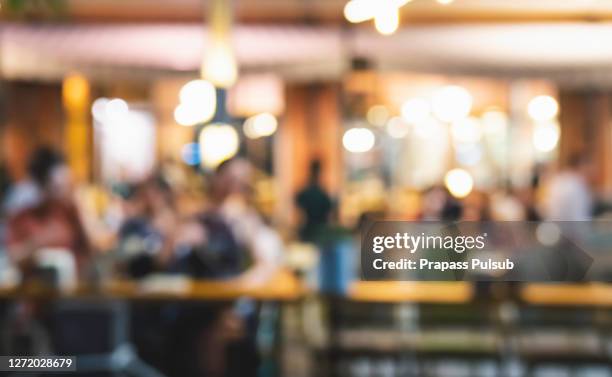 blurred background of restaurant with people. - blurred motion restaurant stock pictures, royalty-free photos & images