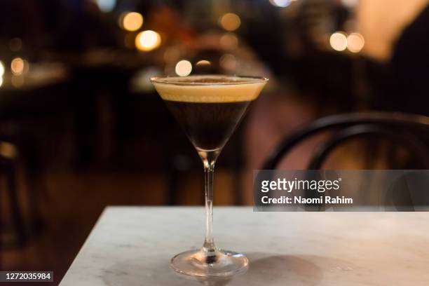 an elegant espresso martini cocktail served in a restaurant, bokeh lights background - australia - espresso martini stock-fotos und bilder