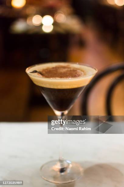 an elegant espresso martini cocktail served in a restaurant, bokeh lights background - australia - espresso martini stock pictures, royalty-free photos & images