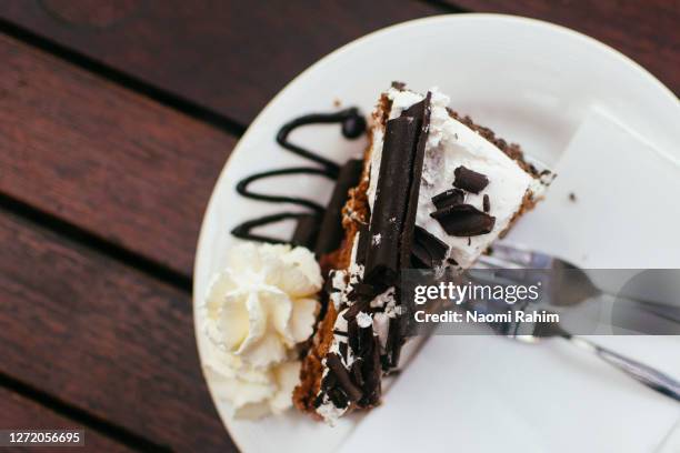 rich black forest cake, served with a dollop of whipped cream on an outdoor table - australia - whip cream dollop stock pictures, royalty-free photos & images