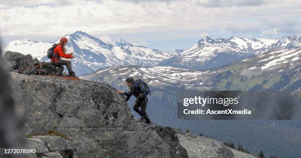 bergsteigerin bestatten freund aufsteigenden bergrücken - gebirgskamm stock-fotos und bilder