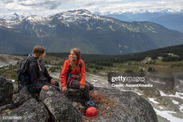 female mountaineers relax on mountain ridge - women rock climbing stock pictures, royalty-free photos & images