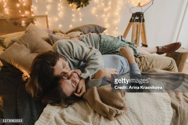 family couple lying on bed at christmas - couple photos et images de collection