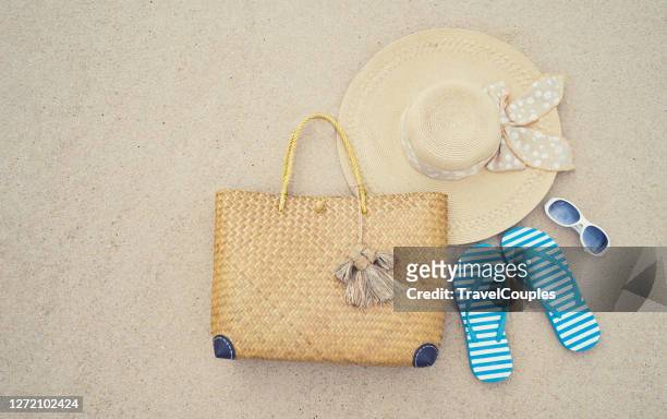 beach accessories. straw hat. bag. sun glasses and flip flops on a tropical beach. fun holiday travel on sandy beach. summertime. summer vibes. - beach bag bildbanksfoton och bilder