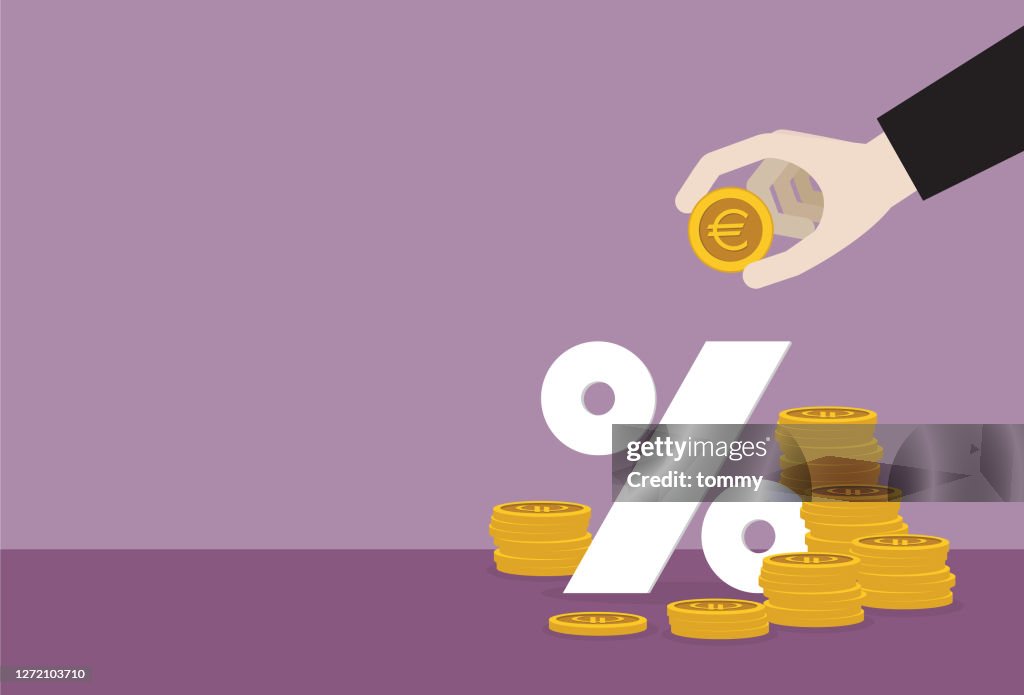 Businessman putting a euro coin into a percentage symbol