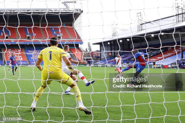 Wilfried Zaha of Crystal Palace scores his team's first goal past Alex McCarthy of Southampton during the Premier League match between Crystal Palace...