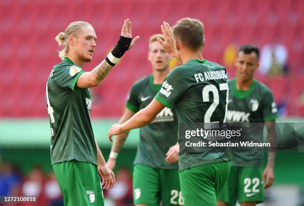 Fredrik Jensen of Augsburg celebrates with Alfred Finnbogason of Augsburg after scoring his team's sixth goal during the DFB Cup first round match...