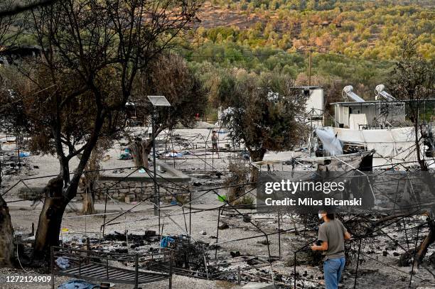 Person walks around the burnt wreckage after a fire destroyed Moria refugee camp located outside of the capitol of the Greek island of Lesbos on...