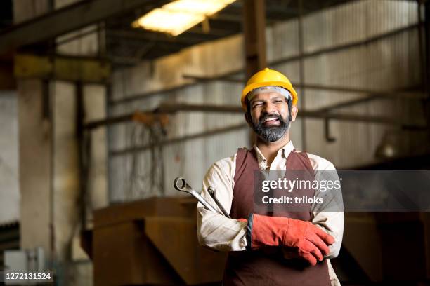 industrial worker holding wrench - metal industry stock pictures, royalty-free photos & images