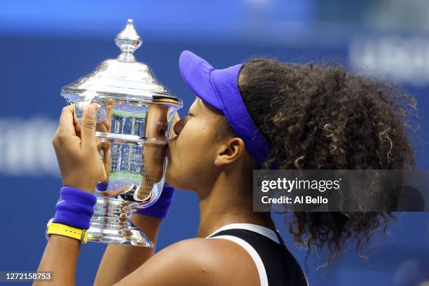 Naomi Osaka of Japan kisses the trophy in celebration after winning her Women's Singles final match against Victoria Azarenka of Belarus on Day...