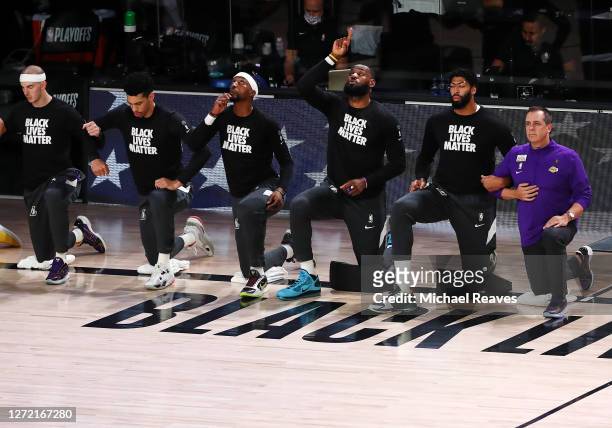 LeBron James of the Los Angeles Lakers, Anthony Davis of the Los Angeles Lakers, and Frank Vogel of the Los Angeles Lakers kneel during the National...