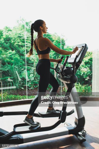 woman training on stepper or treadmill in fitness club of gym. side view. power and endurance functional cardio training. woman health. - peloton tread stock pictures, royalty-free photos & images