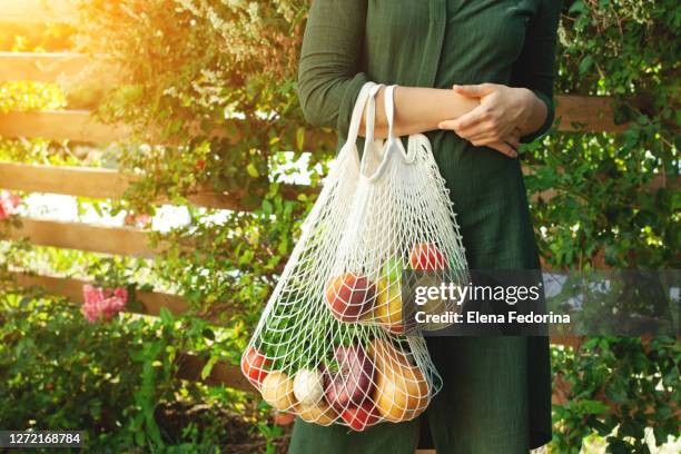 vegetables in an eco bag and girl's hands - tote bag stock pictures, royalty-free photos & images