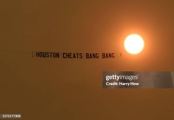 Plane flies over pulling a banner directed at the Houston Astros before the game against the Los Angeles Dodgers at Dodger Stadium on September 12,...