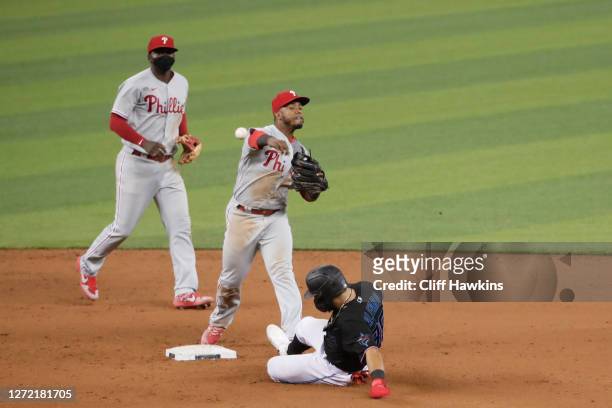 Jean Segura of the Philadelphia Phillies turns the double play for an out on Jorge Alfaro of the Miami Marlins to end the game at Marlins Park on...