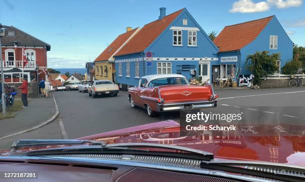 amerikaanse oldtimers rijden in historische vissersdorp gudhjem, bornholm eiland - vissersdorp stockfoto's en -beelden