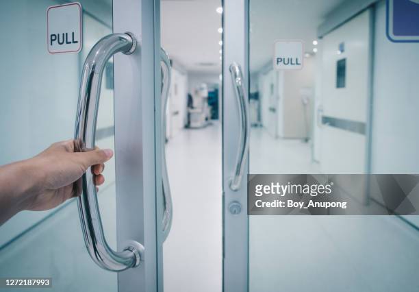 someone hand pulling door for entering to o.r (operating room) area in hospital. - glass entrance imagens e fotografias de stock