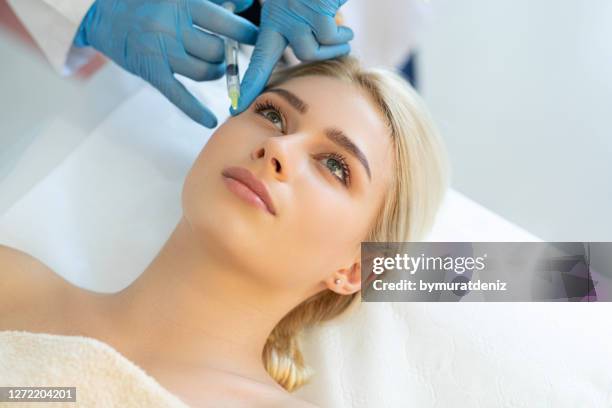 mujer joven en cirugía plástica con jeringa en la cara - plasma rico en plaquetas fotografías e imágenes de stock
