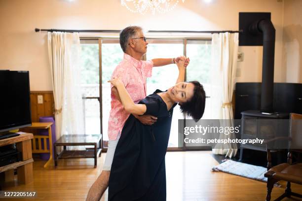 senior japanese couple enjoying time at home dancing - waltzing stock pictures, royalty-free photos & images