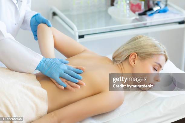 body massage at physiotherapist office - handbook stock pictures, royalty-free photos & images