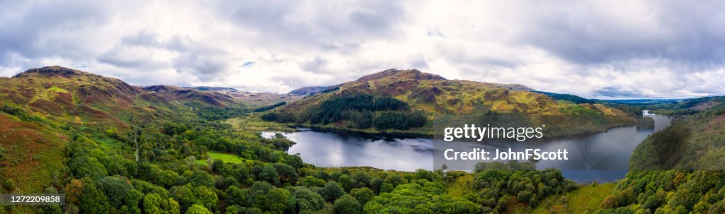 The panoramic aerial view from a drone of a Scottish loch and woodland in Dumfries and Galloway on an overcast day
