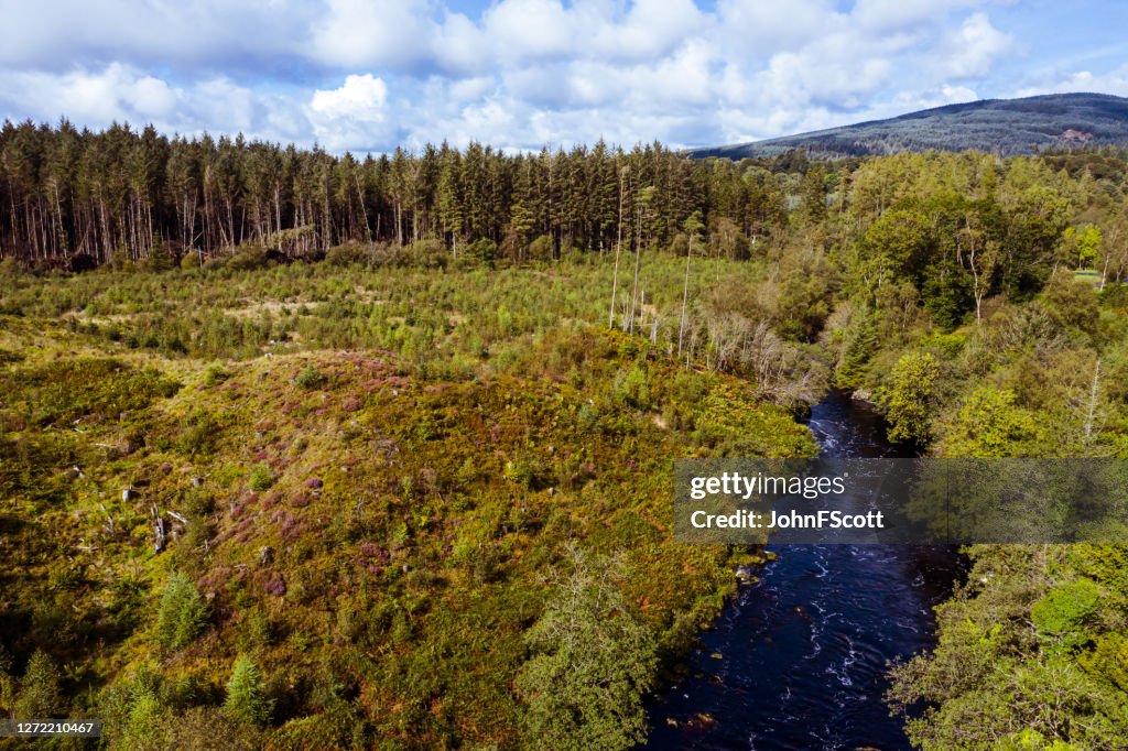 The high angle aerial view of a river flowing through rural Dumfries and Galloway
