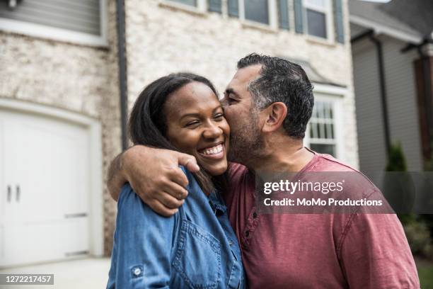 portrait of couple out front of new home - black women kissing white men stock pictures, royalty-free photos & images