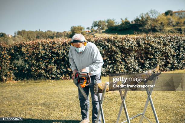 man cutting the wood during the covid - tradesman with chainsaw stock pictures, royalty-free photos & images