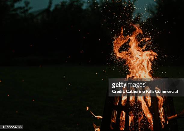 fire pit fiercely burning in the dark with space for copy - tizzone foto e immagini stock