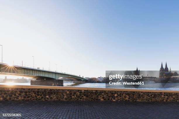 germany, north rhine-westphalia, cologne, sun setting over severinbridge - promenade stock-fotos und bilder