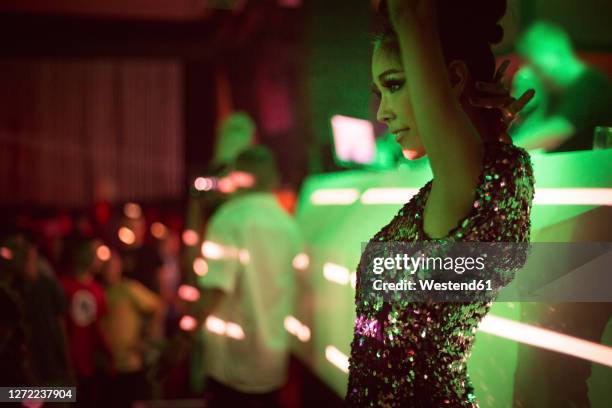 beautiful woman standing with arms raised in club - german greens party stock pictures, royalty-free photos & images