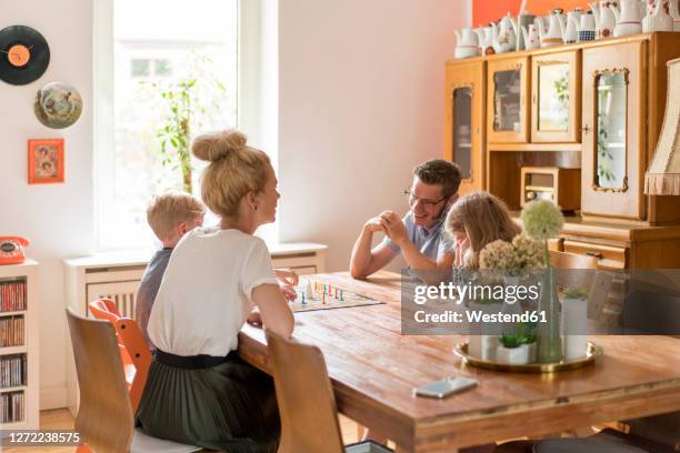 happy family playing board game on dining table at home - spieleabend stock-fotos und bilder