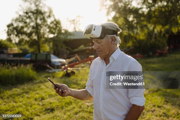 man using phone while wearing vr glasses in backyard - top prospects game ストックフォトと画像