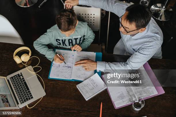 fatherc helping son with his homework - overhead talking stock pictures, royalty-free photos & images