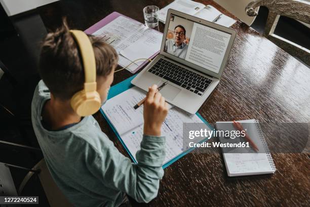 schoolboy learning at home, using laptop and headphones - home school stock pictures, royalty-free photos & images